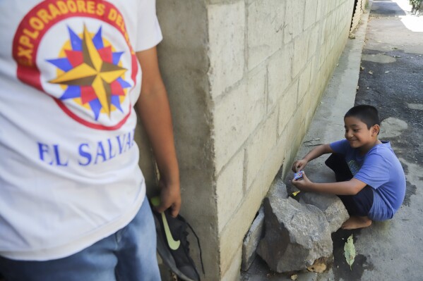 Dilan Recinos Ventura, 8, plays with a box of matches outside the house where he is cared for by his grandmother, after his mother was arrested during the government's crackdown on its war against drugs, in Santa Ana, El Salvador, Wednesday, Jan. 31, 2024. Since the police have swept the neighborhood, Dilan and his 10-year-old brother are now allowed to play outside, so María Concepción Ventura has seen benefits to the crackdown, despite her daughter’s imprisonment. (AP Photo/Salvador Melendez)