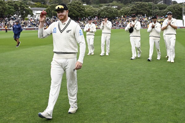 New Zealand bowler Glenn Phillips holds the ball up as he walks from the field after taking five wickets on day three of the first cricket test match between New Zealand and Australia at the Basin Reserve in Wellington, New Zealand, Saturday, March 2, 2024. (Andrew Cornaga/Photosport via AP)