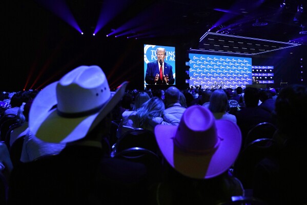 People listen as former President Donald Trump speaks at the Turning Point Action conference, Saturday, July 15, 2023, in West Palm Beach, Fla. (AP Photo/Lynne Sladky)