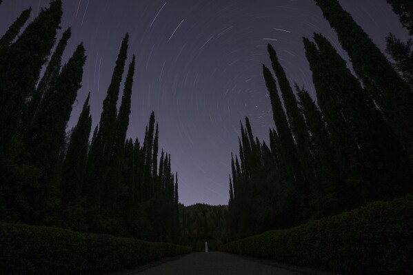 The monument where is placed the heart of French Baron Pierre de Coubertin is seen under the night sky in ancient Olympia, early Wednesday, April 10, 2024. Just outside the site of the ancient Olympic Games, hooting owls break the night-time silence at a white marble monument containing what's left of a singular Frenchman's heart. (AP Photo/Petros Giannakouris)