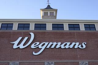 CORRECTS DATE OF ANNOUNCEMENT - FILE - A Wegmans sign is attached to the outside of a Wegmans supermarket location, Tuesday, Dec. 20, 2022, in Westwood, Mass. The Wegmans supermarket chain is closing one of its largest and most unusual stores because it has not attracted enough business, the company said. The Natick, Massachusetts store will close on an undetermined date this summer, the Rochester, New York-based company said in a statement on Thursday, June 1, 2023. (AP Photo/Steven Senne, File)