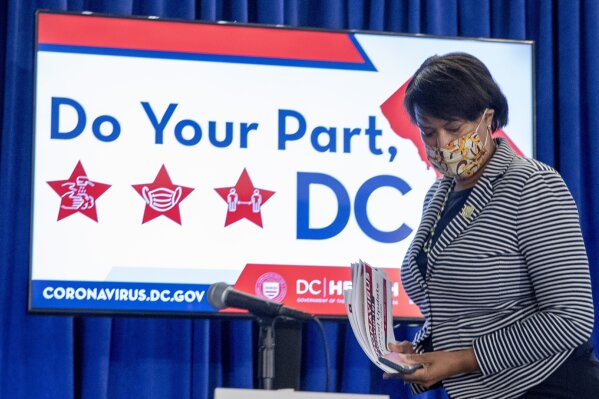 District of Columbia Mayor Muriel Bowser wears a face mask to protect against the spread of the coronavirus outbreak, as she leaves a news conference on the coronavirus and the District's response, Monday, July 20, 2020 in Washington.  In the face of newly rising infection numbers, Bowser says she'll issue an executive order making face masks mandatory outside the home. (AP Photo/Andrew Harnik)