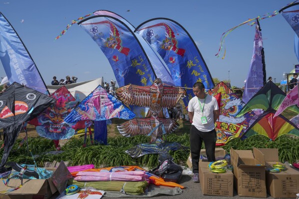 A kite vendor waits for customers at the 41st International Kite Festival in Weifang, Shandong Province of China, Saturday, April 20, 2024. (AP Photo/Tatan Syuflana)