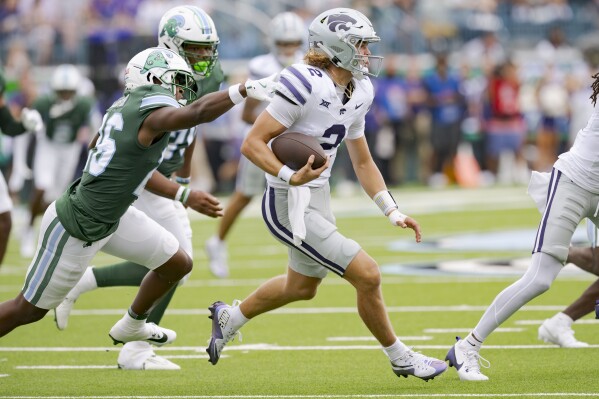 Kansas State quarterback Avery Johnson (2) runs as Tulane safety Shi'Keem Laister (26) closes in during the first half of an NCAA college football game in New Orleans, Saturday, Sept. 7, 2024. (AP Photo/Matthew Hinton)