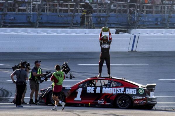 Ross Chastain, top, celebrates by slamming a watermelon to the ground after winning a NASCAR Cup Series auto race Sunday, April 24, 2022, in Talladega, Ala. (AP Photo/Skip Williams)