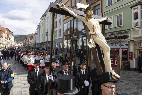The Passion statue "The Crucifixion" is carried in the Palm Sunday procession of the Catholic faithful in Heiligenstadt, Germany, Sunday, April 13, 2025. (Michael Reichel/dpa via AP)