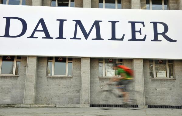 FILE - A cyclist passes a logo of German car company Daimler in Berlin on April 8, 2009. German truck maker Daimler, Japan’s top automaker Toyota and two other automakers said Tuesday, May 30, 2023, they will work together on new technologies, including use of hydrogen fuel, to help fight climate change. (AP Photo/Gero Breloer, File)