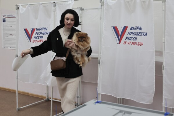 A woman holds her pet as she leaves a voting booth during a presidential election in the Pacific port city of Vladivostok, 6,416 km (3,987 miles) east of Moscow, Russia, Sunday, March 17, 2024. Voters in Russia went to the polls for the last day of a presidential election that was all but certain to extend President Vladimir Putin's rule after he clamped down on dissent. (AP Photo)