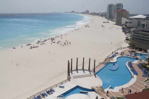 FILE - Tourists hang out on the Gaviota Azul beach in Cancun, Mexico, March 2, 2010. A four-day inspection raid targeting drugstores in Cancun, Playa del Carmen and Tulu resulted in the shuttering of 23 pharmacies at Caribbean coast resorts, six months after a report warned that the drug stores were offering foreigners pills they passed off as Oxycodone, Percocet and Adderall without prescriptions, the Navy Department said Tuesday, Aug. 8, 2023. (AP Photo/Israel Leal, File)