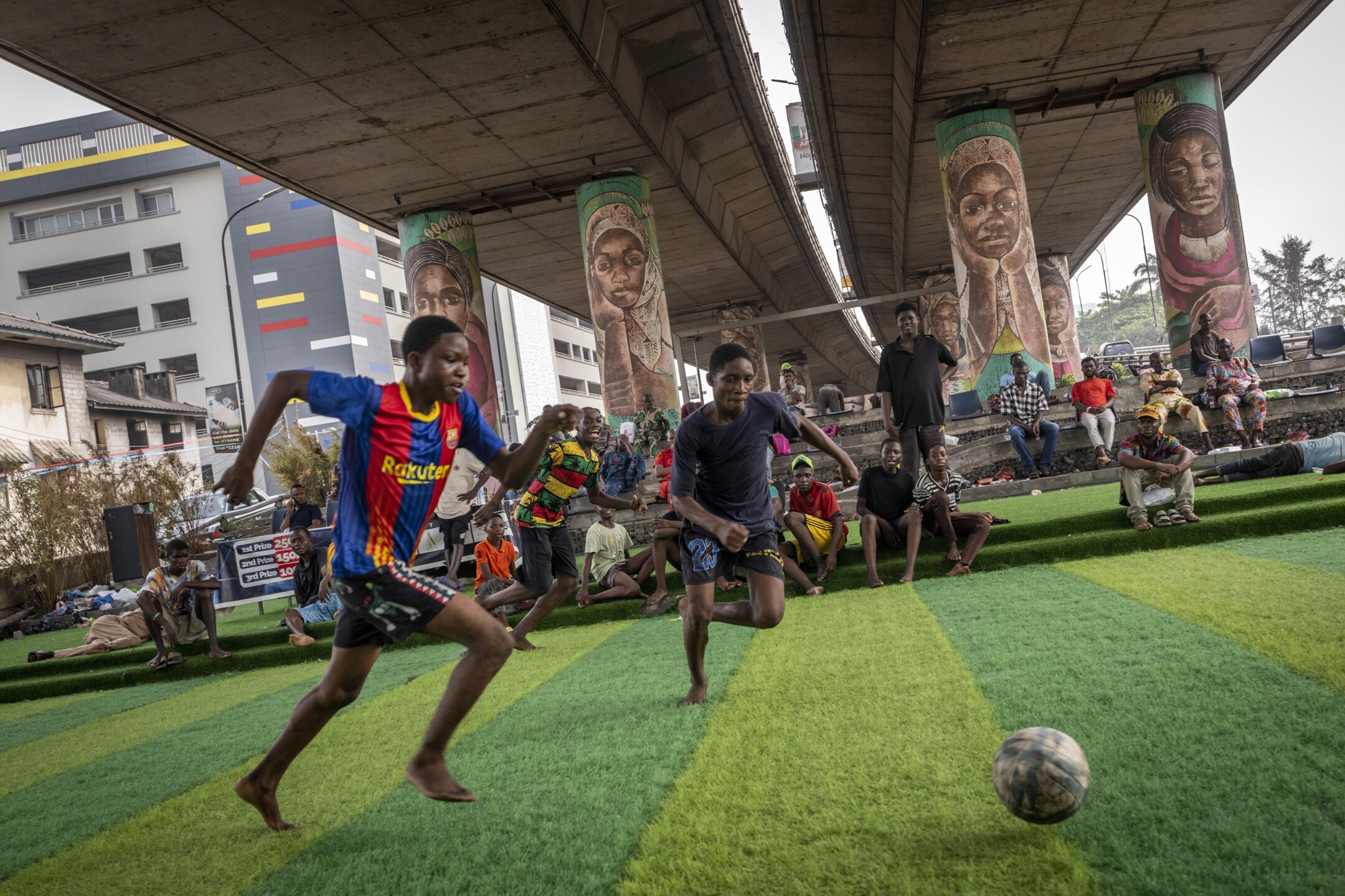 Youth play football underneath a highway overpass on Ikoyi Island, Lagos, Nigeria, on Feb. 23, 2023. (AP Photo/Ben Curtis)