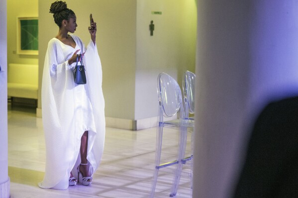 A fashionista takes a selfie during the second day of Johannesburg Fashion Week 2023, in Johannesburg, South Africa, Thursday, Nov. 9, 2023. (AP Photo/Jerome Delay)