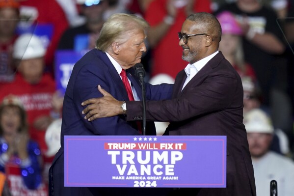 Republican presidential nominee former President Donald Trump, left, greets Roberto Clemente Jr., right, at a campaign rally at PPG Paints Arena, Monday, Nov. 4, 2024, in Pittsburgh. (AP Photo/Matt Freed)