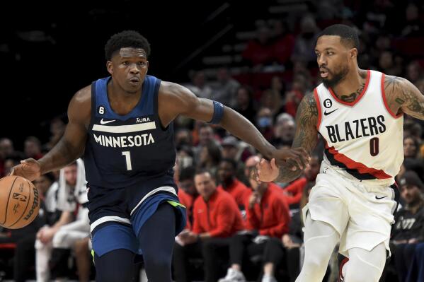Minnesota Timberwolves guard Anthony Edwards, left, brings the ball up the court on Portland Trail Blazers guard Damian Lillard, right, during the first half of an NBA basketball game in Portland, Ore., Monday, Dec. 12, 2022. (AP Photo/Steve Dykes)