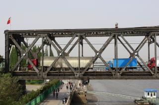 FILE - In this May 24, 2018, file photo, trucks cross the friendship bridge connecting China and North Korea in the Chinese border town of Dandong, opposite side of the North Korean town of Sinuiju. China has restored railway freight traffic with North Korea that had been suspended over pandemic infection concerns, the Foreign Ministry said Monday, Jan. 17, 2022. (Chinatopix via AP, File)
