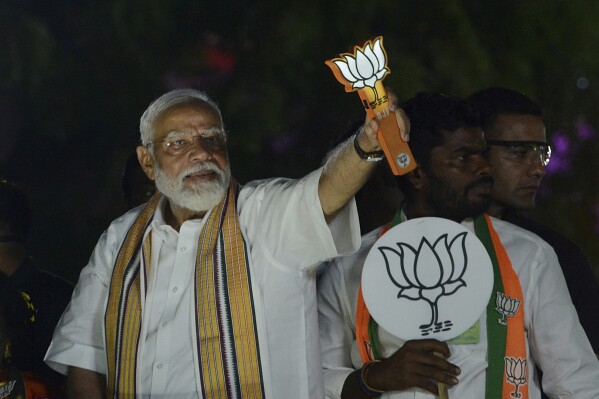FILE- Indian Prime Minister Narendra Modi displays the Bharatiya Janata Party symbol during an election road show in the southern Indian city of Chennai, India, Tuesday, April 9, 2024. (AP Photo/File)