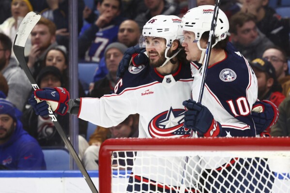 Columbus Blue Jackets right wing Kirill Marchenko, left, celebrates his hat trick against the Buffalo Sabres with left wing Dmitri Voronkov (10) during the second period of an NHL hockey game Tuesday, Dec. 19, 2023, in Buffalo, N.Y. (AP Photo/Jeffrey T. Barnes)