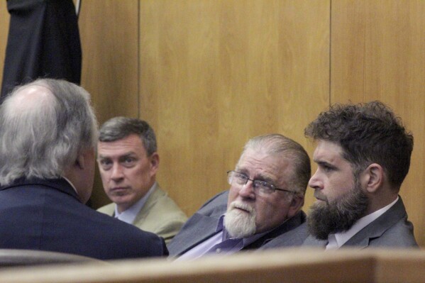 Gregory Case, the father, center, and Brandon Case, the son, right, speak with an attorney, Wednesday, Aug. 16, 2023, at the Lincoln County Courthouse in Brookhaven, Miss. Both men were indicted for conspiracy to murder, attempted murder and shooting into a motor vehicle in relation to a January 24, 2022 shooting at a Black FedEx driver. (Hunter Cloud/The Daily Leader via AP)