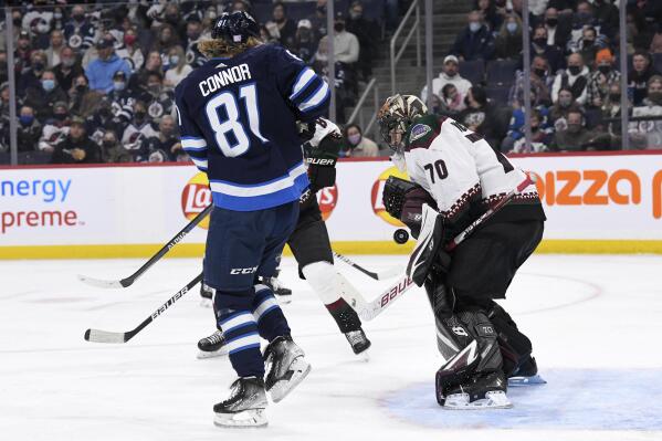 Arizona Coyotes goaltender Karel Vejmelka (70) makes a save as Winnipeg Jets' Kyle Connor (81) looks for a rebound during the second period of NHL hockey game action in Winnipeg, Manitoba, Monday, Nov. 29, 2021. (Fred Greenslade/The Canadian Press via AP)