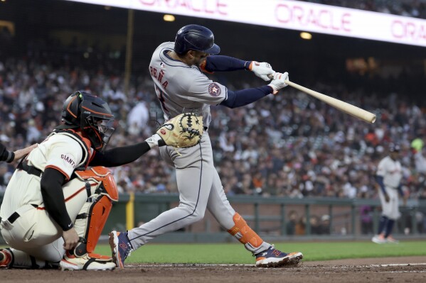 CORRECTS TO SEVENTH INNING NOT FIRST INNING - Houston Astros' Jeremy Peña, right, hits an RBI sacrifice fly in front of San Francisco Giants catcher Patrick Bailey, left, during the seventh inning of a baseball game in San Francisco, Monday, June 10, 2024. (AP Photo/Jed Jacobsohn)