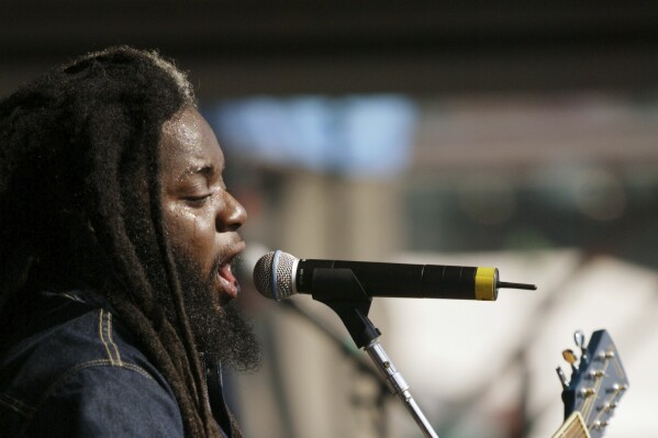 FILE - Reggae singer Peter Anthony Morgan of Morgan Heritage performs on the at the New Orleans Jazz and Heritage festival Saturday, May 4, 2002, in New Orleans. Peter Morgan, lead singer of the popular reggae band Morgan Heritage that he founded with five siblings, died Sunday, Feb. 25, 2024, at age 46, his family announced. Morgan, known as 鈥淧eetah,鈥� was a son of renowned Jamaican reggae singer Denroy Morgan. (AP Photo/Douglas Mason, File)