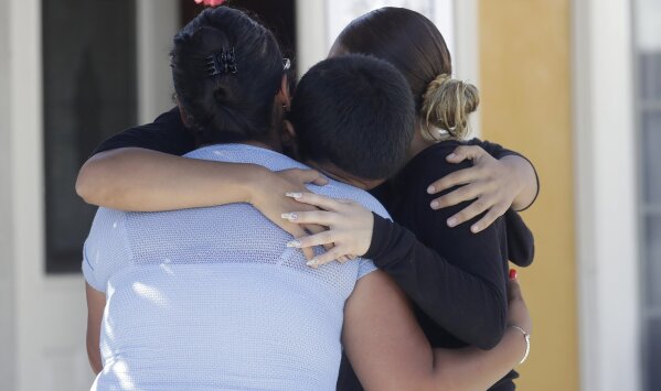 Joshua Guicho, 16, center, hugs his aunts Josephine Guicho, left, and Erica Guicho after being interviewed about the shooting death of his 6-year-old cousin Stephen Romero in San Jose, Calif., Monday, July 29, 2019. Romero is one of three young people who died when a gunman opened fire at a popular California food festival Sunday. (AP Photo/Jeff Chiu)