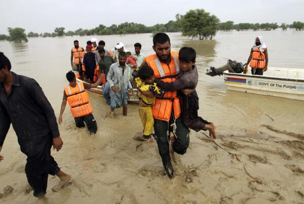 Army troops evacuate people from a flood-hit area in Rajanpur, district of Punjab, Pakistan, Saturday, Aug. 27, 2022. Officials say flash floods triggered by heavy monsoon rains across much of Pakistan have killed nearly 1,000 people and displaced thousands more since mid-June. (AP Photo/Asim Tanveer)