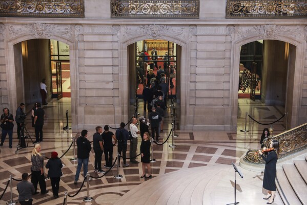 Members of the public line up single file to sign condolences books after paying their respects as the casket of Sen. Dianne Feinstein is displayed in the Rotunda of City Hall in San Francisco, Wednesday, Oct. 4, 2023. (Jessica Christian/San Francisco Chronicle via AP)