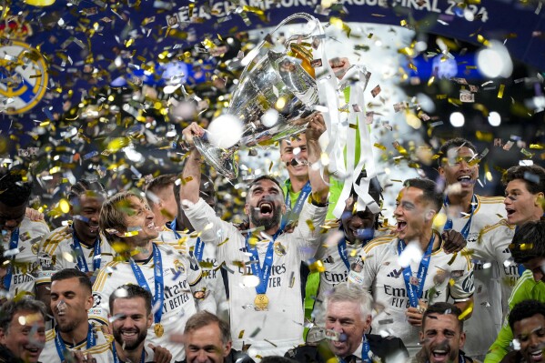 Real Madrid's players celebrate with the trophy after winning the Champions League final soccer match between Borussia Dortmund and Real Madrid at Wembley stadium in London, Saturday, June 1, 2024. (AP Photo/Kirsty Wigglesworth)