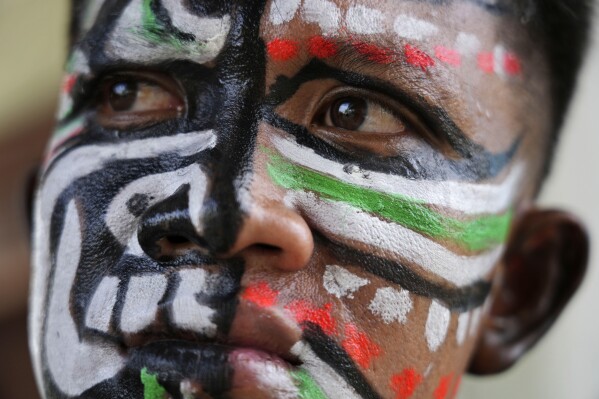 A man, his face painted in the likeness of a spirit, participates in the He Neak Ta rituals in Phum Boeung village, northwest of Phnom Penh, Cambodia, Tuesday, June 11, 2024. Cambodian villagers on Tuesday took part in a rare traditional guardian spirit ceremony praying for good fortune, rain and prosperity, as they aimed to preserve this ancient tradition. (AP Photo/Heng Sinith)