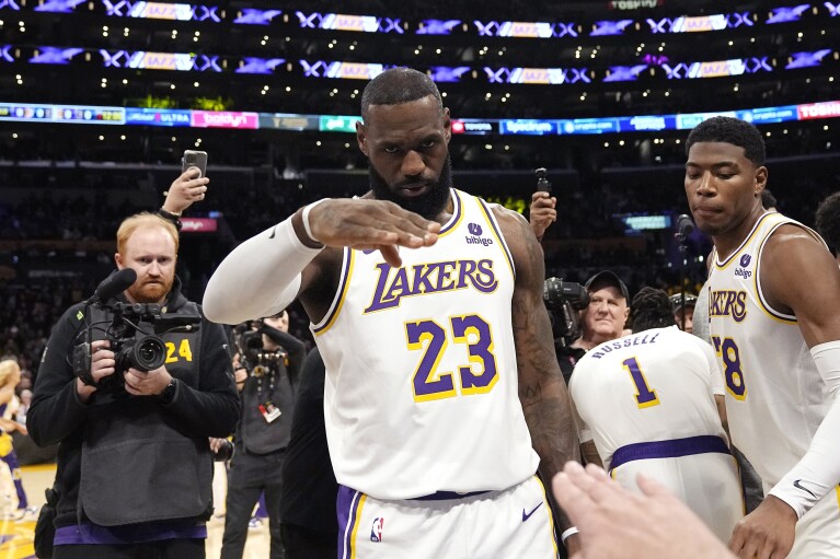 Los Angeles Lakers forward LeBron James salutes public address announcer Lawrence Tanter prior to an NBA basketball game against the Denver Nuggets Saturday, March 2, 2024, in Los Angeles. (AP Photo/Mark J. Terrill)