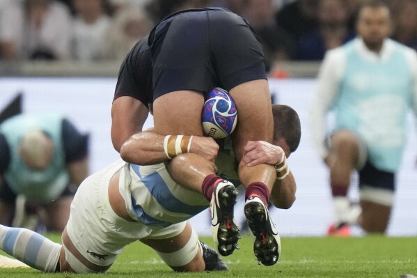 England's Ellis Genge, top is tackled by Argentina's Marcos Kremer during the Rugby World Cup Pool D match between England and Argentina in the Stade de Marseille, Marseille, France Saturday, Sept. 9, 2023. (AP Photo/Pavel Golovkin)