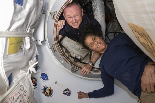 In this photo provided by NASA, Boeing Crew Flight Test astronauts Butch Wilmore, left, and Suni Williams pose for a portrait inside the vestibule between the forward port on the International Space Station's Harmony module and Boeing's Starliner spacecraft on June 13, 2024. (NASA via AP, File)