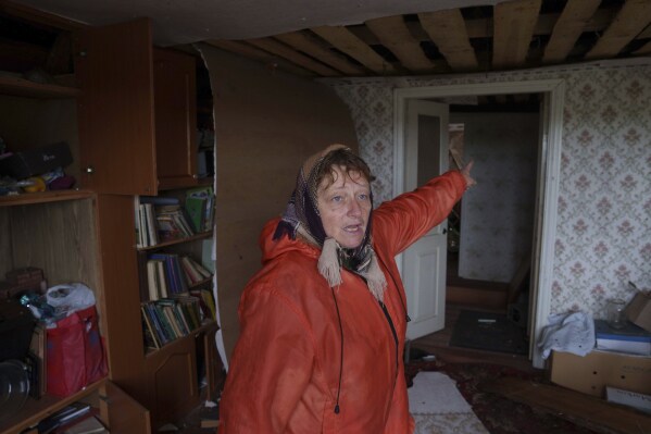 A woman reacts inside a house damaged by a Russian strike in Korostyshiv, Zhytomyr region, Ukraine, Sunday, May 25, 2025. (AP Photo/Evgeniy Maloletka)