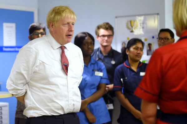 Britain's Prime Minister Boris Johnson speaks to mental health professionals during his visit to Watford General Hospital, in Watford, Monday, Oct. 7, 2019. Britain and the European Union appeared to be poles apart Monday on a potential Brexit deal, with the Dutch government urging the British government to offer "more realism and clarity," and U.K. Prime Minister Boris Johnson insisting the bloc has to soften its stance. (Peter Summers/Pool Photo via AP)