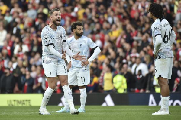 Liverpool's Jordan Henderson, left, reacts with his teammates Mohamed Salah, center and Trent Alexander-Arnold after Arsenal's Bukayo Saka scored during the English Premier League soccer match between Arsenal and Liverpool at Emirates Stadium in London, Sunday, Oct. 9, 2022. (AP Photo/Rui Vieira)