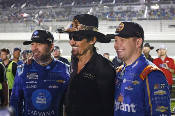 Former NASCAR driver Richard Petty, center, poses for a photo with Jimmie Johnson, left, and Erik Jones, right, before the first of two qualifying auto races for the NASCAR Daytona 500 at Daytona International Speedway, Thursday, Feb. 16, 2023, in Daytona Beach, Fla. (AP Photo/Terry Renna)