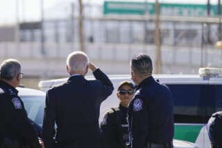 FILE - President Joe Biden, second from left, looks towards a large "Welcome to Mexico" sign that is hung over the Bridge of the Americas as he tours the El Paso port of entry, a busy port of entry along the U.S.-Mexico border, in El Paso Texas, Sunday, Jan. 8, 2023. (AP Photo/Andrew Harnik, File)