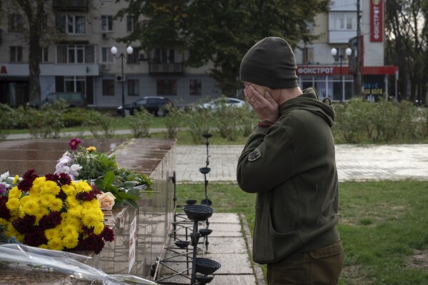 A servicewomen cries as she lays flowers to commemorate those killed in the war, as the city marks one year since Ukraine retook the city of Kherson from occupying Russian forces in Kherson, Ukraine, Saturday, Nov. 11, 2023. (AP Photo/Efrem Lukatsky)