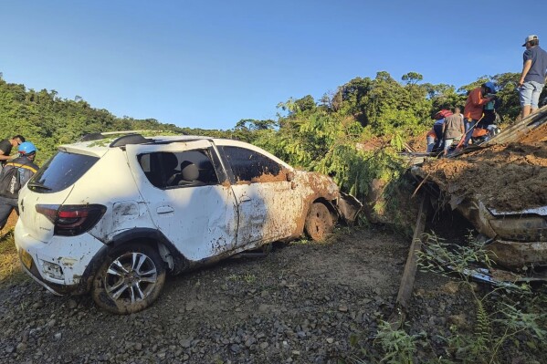 In this handout photo released by the Colombian Army Press Office, a rescue team searches for survivors of a mudslide that killed several people and left dozens injured, in western Colombia, Saturday, Jan. 13, 2024. The avalanche covered a highway on a busy municipal road in a mountainous area connecting the cities of Quibdo and Medellin. (Colombian Army Press Office via AP)