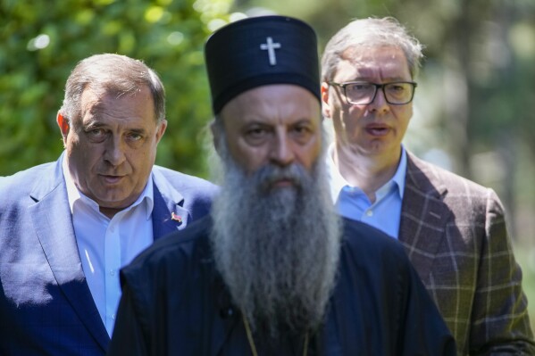 Serbian Orthodox Church Patriarch Porfirije, center, walks with Bosnian Serb leader Milorad Dodik, left, and Serbian President Aleksandar Vucic, before their meeting in Belgrade, Serbia, Thursday, July 20, 2023. They talked about the situation in the region and upcoming important meetings between the delegations of the Republic of Serbia and the Republic of Srpska. (AP Photo/Darko Vojinovic)