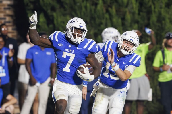 Duke's Jordan Waters (7) and Riley Leonard (13) celebrate after scoring a touchdown late in the second half of an NCAA college football game against Clemson in Durham, N.C., Monday, Sept. 4, 2023. (AP Photo/Ben McKeown)