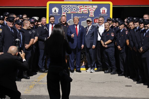 Republican presidential nominee former President Donald Trump, center and Republican vice presidential nominee Sen. JD Vance, R-Ohio, pose for a photo with firefighters from Engine 4 Ladder 15 on the 23rd anniversary of the Sept. 11, 2001 terror attacks, Wednesday, Sept. 11, 2024, in New York. (AP Photo/Stefan Jeremiah)