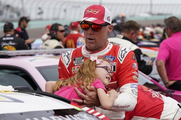 Kevin Harvick pulls his daughter Piper from his car before a NASCAR Cup Series auto race at Homestead-Miami Speedway, Sunday, Oct. 22, 2023 in Homestead, Fla. (AP Photo/Wilfredo Lee ).