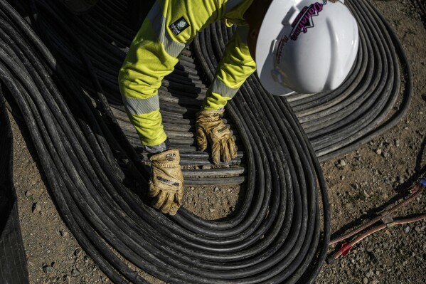 A worker lays cables at Energy Vault, a company that is creating an emergency power system that relies on hydrogen and battery storage, on Tuesday, May 27, 2025, in Calistoga, Calif. (AP Photo/Annika Hammerschlag)