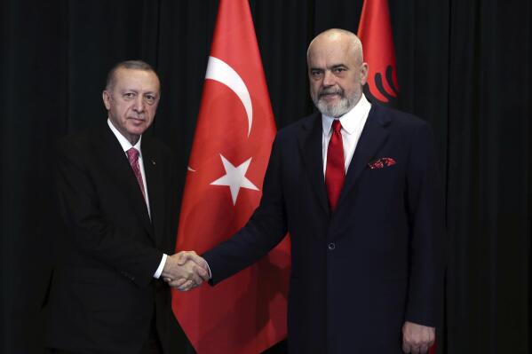 In this photo provided by Turkish Presidency, Albanian Prime Minister Edi Rama, right, shakes hands with Turkish President Recep Tayyip Erdogan during their meeting in Tirana, Albania, Monday, Jan. 17, 2022. Turkish President Recep Tayyip Erdogan is visiting Albania to talk with Prime Minister Edi Rama on strengthening bilateral ties. Erdogan also visits a northwestern town of Lac where Turkey has funded the building of some 500 apartments destroyed by the 2019 earthquake in the tiny Western Balkan country. (Turkish Presidency via AP)