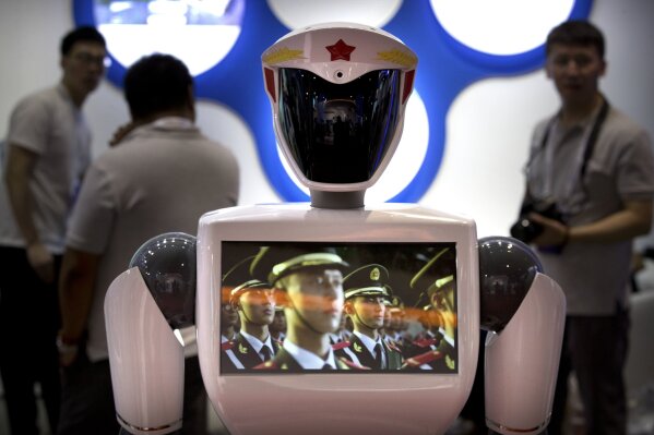 
              FILE - In this Aug. 15, 2018, file photo, a video screen plays footage of Chinese People's Liberation Army (PLA) soldiers on a robot from a Chinese robot maker at the World Robot Conference in Beijing. For four decades, Beijing has cajoled or pressured foreign companies to hand over technology. And its trading partners say if that didn't work, China stole what it wanted. (AP Photo/Mark Schiefelbein, File)
            