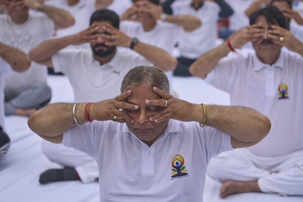 Activists of India's ruling Bharatiya Janata Party (BJP), perform yoga on the International Day of Yoga at the city centre in Srinagar, Indian controlled Kashmir, Saturday, June 21, 2025. (AP Photo/Dar Yasin)