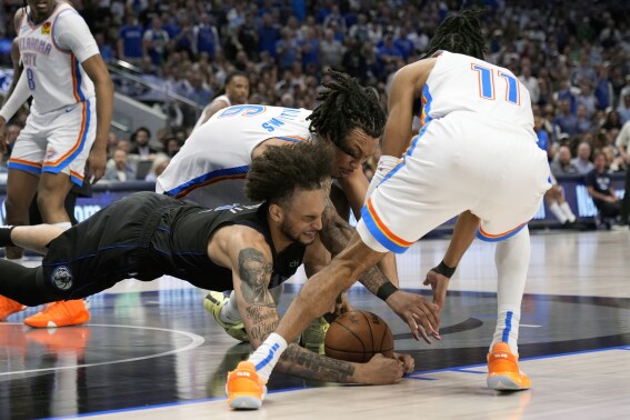 Dallas Mavericks center Dereck Lively II, left, Oklahoma City Thunder's Jaylin Williams and Isaiah Joe (11) scramble to control the ball in the second hald of Game 6 of an NBA basketball second-round playoff series Saturday, May 18, 2024, in Dallas. (AP Photo/Tony Gutierrez)