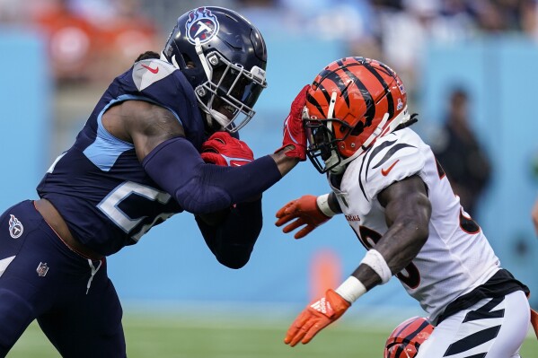 Tennessee Titans running back Derrick Henry (22) hits Cincinnati Bengals safety Nick Scott (33) during the second half of an NFL football game, Sunday, Oct. 1, 2023, in Nashville, Tenn. (AP Photo/George Walker IV)
