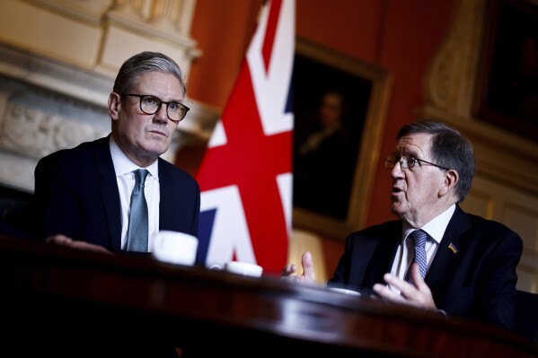 Britain's Prime Minister Keir Starmer listens to Member of the House of Lords George Robertson, right, during a joint meeting with Britain's Defence Secretary John Healey (unseen) at 10 Downing Street, in London, Tuesday, July 16, 2024. Former NATO leader George Robertson will lead a review of Britain’s military strategy to counter what he calls the “deadly quartet” of China, Iran, Russia and North Korea. Prime Minister Keir Starmer announced the strategic defense review on Tuesday, July 16, 2024 as one of his first major acts after taking office on July 5. Starmer who leads a center-left Labour Party government, has promised to end the shrinking of the U.K.’s military seen during 14 years of Conservative Party rule. (Benjamin Cremel/Pool photo via AP)